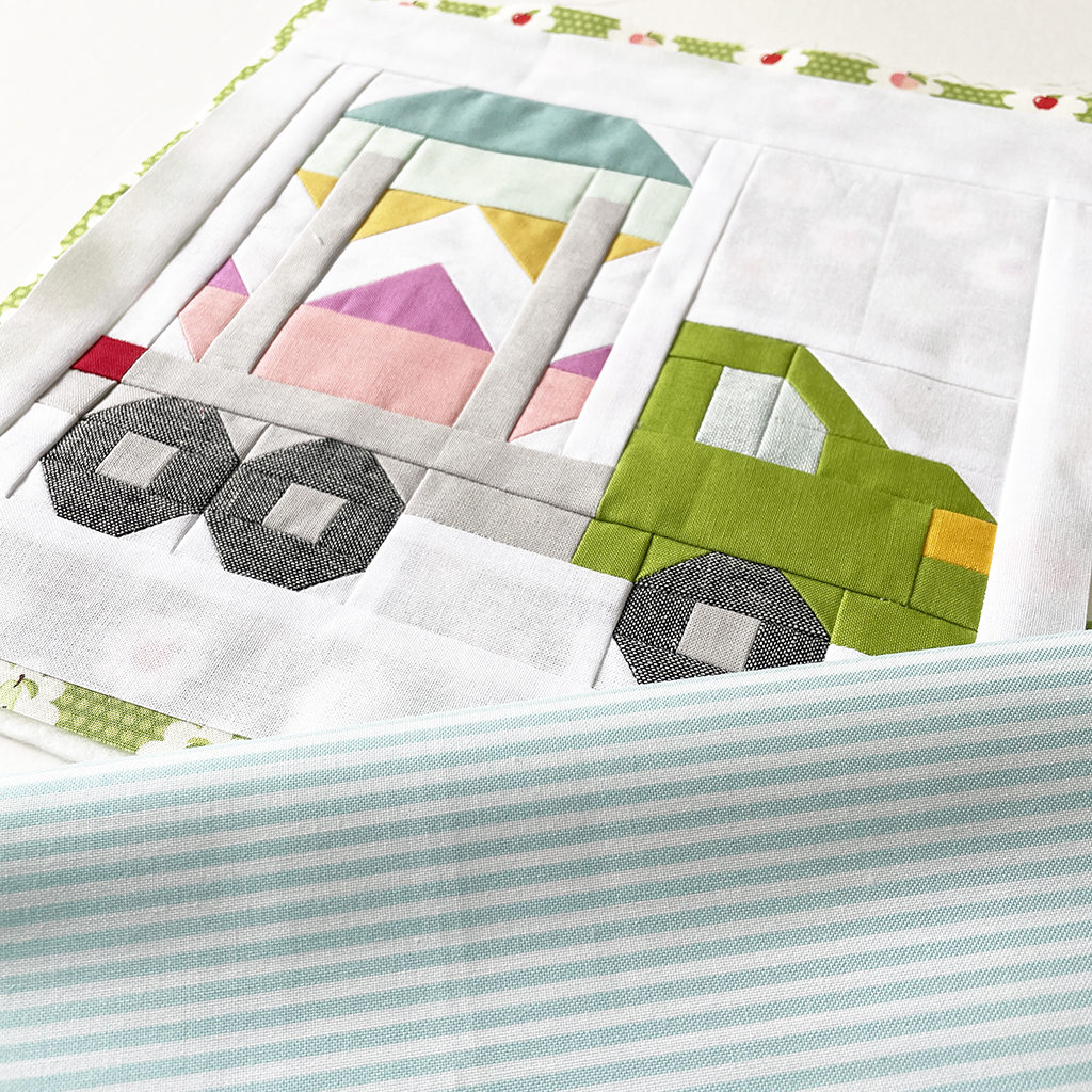 Vehicle Quilt Block Lastwagen mit Riesen-Ei und türkis-weiß gestreiftem Bindingstoff auf weißem Hintergrund