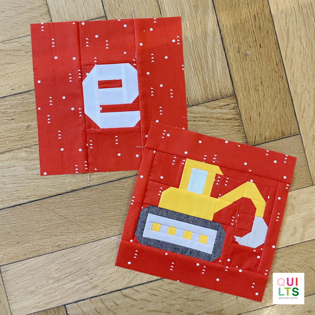 Letter-Vehicle Quilt letter block e und vehicle block excavator liegt auf Parkett 