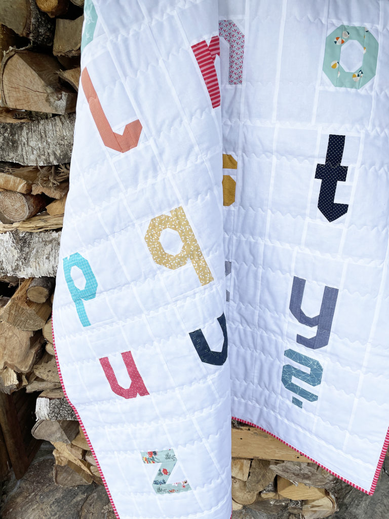 Letter Quilt hängt über einem Holzstapel Auschnitt