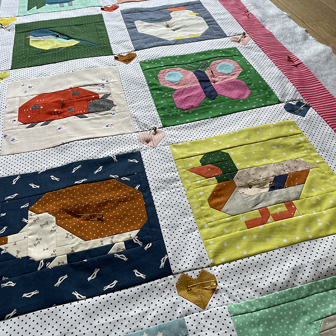 Bunter Animal Quilt Ausschnitt mit Quiltingnadeln auf dem Boden liegend